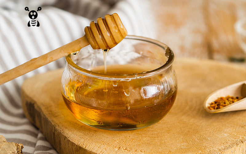 honey in a glass jar with honey dipper